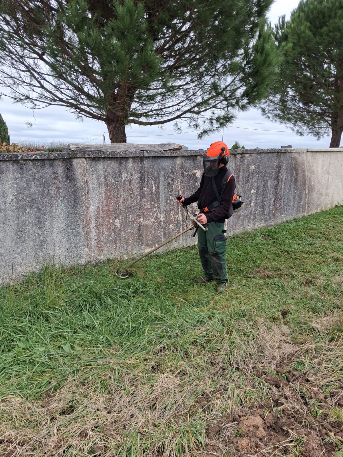 Cyril travailleur des espaces verts en train de passer le rotofile sur les hautes herbes.